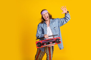 Full body portrait of cool young man have fun boombox wear denim shirt isolated on yellow color background