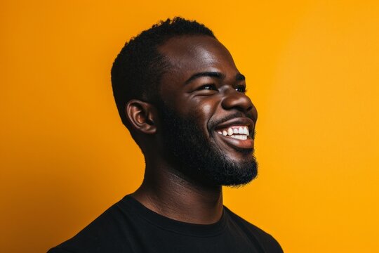 Cheerful african american man smiling and looking away against yellow background