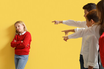 Classmates bullying little girl on yellow background - obrazy, fototapety, plakaty