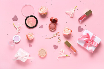 Makeup products with earrings, gift boxes and flowers on pink background