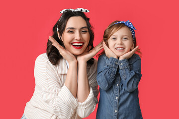 Beautiful pin-up woman and her daughter on red background - obrazy, fototapety, plakaty