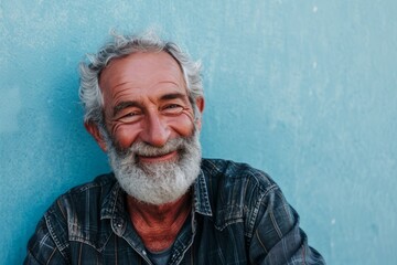 Portrait of an old man with a white beard against a blue wall