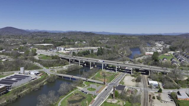 Aerial Drone Footage of Downtown Asheville North Carolina on a sunny spring day with the Appalachian Mountains and a bright blue sky in the background