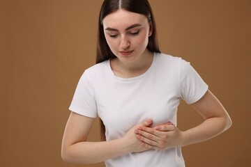 Obraz premium Woman having heart attack on brown background