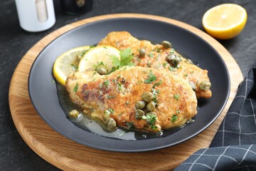 Delicious chicken piccata served on black table