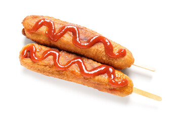 Tasty corn dogs with ketchup on white background