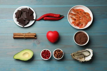 Fotobehang Natural aphrodisiac. Different food products and heart model on light blue wooden table, flat lay © New Africa