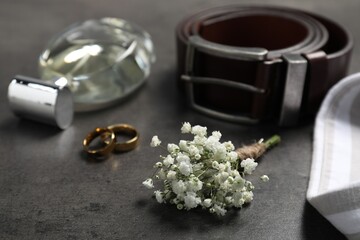 Wedding stuff. Composition with stylish boutonniere on black table, closeup - obrazy, fototapety, plakaty