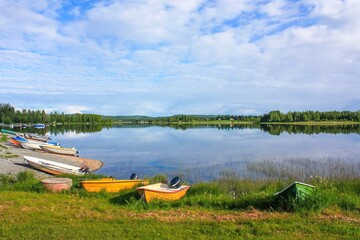 A serene scene of colorful boats gently bobbing on tranquil waters of a peaceful lake, mirroring...