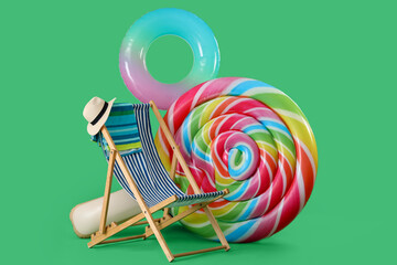 Sun lounger, inflatable ring and swimming mattress in shape of candy on green background