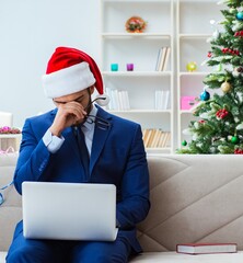 Businessman working at home during christmas - 782614458