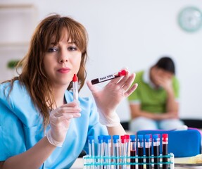 Young lab assistant testing blood samples in hospital - 782618096