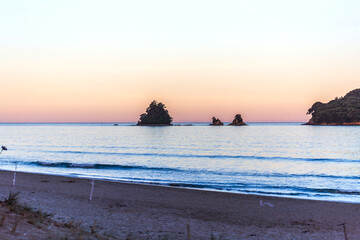 A Breathtaking View of Whangamata Beach as the Sun Sets, Casting a Spectacular Purple Glow Across the Sky,
