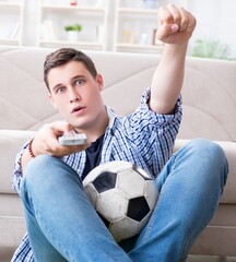 Young man student watching football at home - 782623611