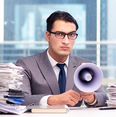 Angry businessman with loudspeaker in the office - 782624264