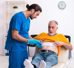 Old man visiting young male doctor