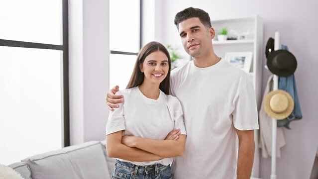 A smiling couple stands together in a modern living room, emanating love and companionship.