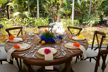 Mexican themed event setting decoration dinner table setting plates glassware on tropical forest background