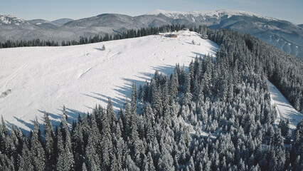 Ski resort at snow mountain top aerial. Nobody nature landscape. Winter snowy slope. Tourists attraction for mountaineering. Vacation for extreme, active sport. Carpathians, Bukovel, Ukraine, Europe