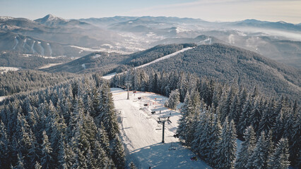 Ski slope, escalator at snow mountain aerial. Winter nature landscape. Pine forest. Extreme sport...