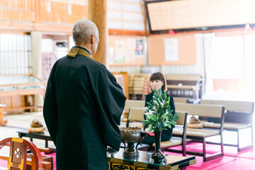 葬式で法話や説教をする住職・お坊さんと遺族（お寺・本堂）
