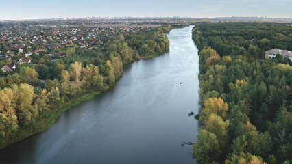 Closeup green forest at river aerial. Nobody nature landscape. Cityscape at leaf trees. Greenery park at urban streets. Cottages at stream banks. Natural beauty of Dnieper, Kiev city, Ukraine, Europe