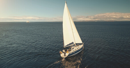 Yacht cruise in sunlight reflection at open sea bay aerial. Luxury sailboat sailing at Brodick...