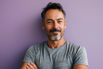 Portrait of a handsome mature man with beard and mustache against purple background