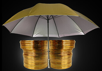 two stacks of gold coins under an open umbrella on a black background. fund protection concept