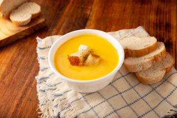 Homemade carrot and pumpkin cream soup. Easy, nutritious and healthy recipe. Served in a white bowl with bread croutons. Perfect to accompany everyday food. - 782703011