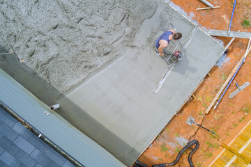 Leveling concrete by using special tool by construction worker