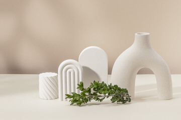 Stylish composition with a vase, plaster figures and a boxwood branch. Product presentation. Copy...