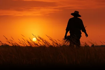 Foto op Canvas Farmer's silhouette of a stunning paddy field sunset © KerXing