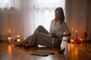 young woman indoor with nail board and burning candles - 782720239