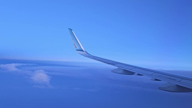 Flying above the blue sky clouds on sunset of airplane flight. View from the window of the plane in Vietnam .
