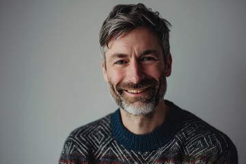 Portrait of a happy senior man with grey hair and beard looking at camera