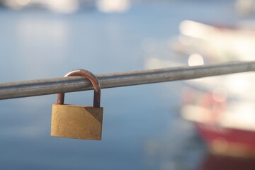 padlock on the railing on the background of the sea and boats