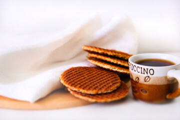 Cup of coffee and Dutch waffle sweet called a Stroopwafel.