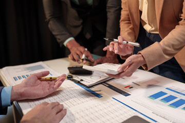 Group of modern business people pointing to data from graph papers Chart discussing in the...