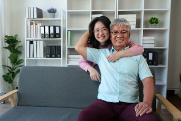 Surprised Asian woman hugs elderly father Teasing in various verses Reading in the living room...