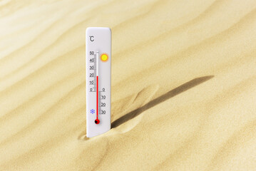 Hot summer day. Celsius scale thermometer in the sand. Ambient temperature plus 21 degrees