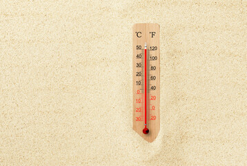 Hot summer day. Celsius and fahrenheit scale thermometer in the sand. Ambient temperature plus 50 degrees