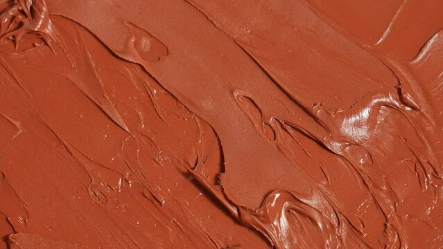 The knife spreads the nut butter onto the bread. macro close-up Chocolate cream, structure