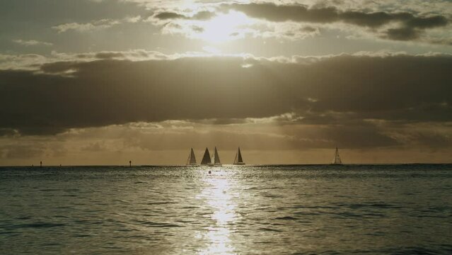 View of the sea at sunset on Waikiki Beach, with boats sailing in the distant background in Hawaii