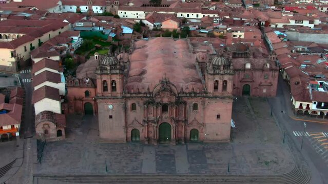 Dolly in tilt up aerial over the Cusco Cathedral facade reveals the San Blas neighborhood