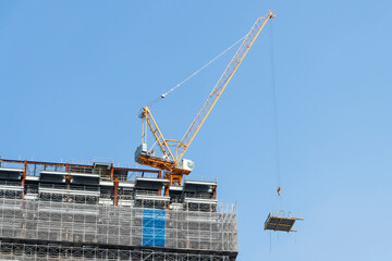 Building construction site and cranes with a blue sky background.