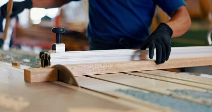 Hands, man and carpenter with cutting for wood at workshop for furniture and design. Closeup, carpentry and machine on startup business for manufacturing in warehouse, factory and handyman.