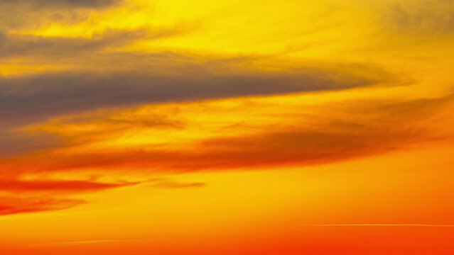 Vibrant fiery sunset or sunrise sky with clouds, time lapse