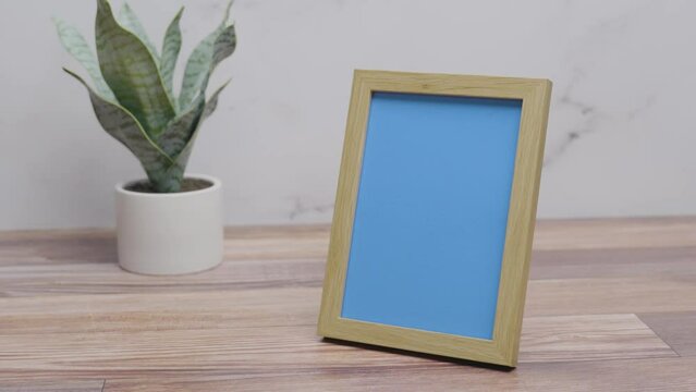 Picture frame with replaceable blue screen on countertop with white background | 4K