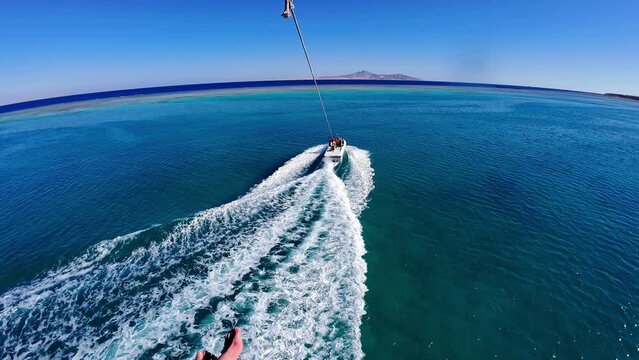 POV of parasailing over blue ocean